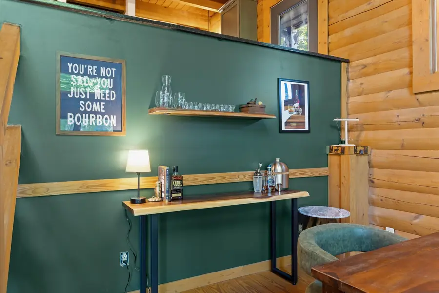 Built-in bar with shelving, bottles and a framed bourbon sign