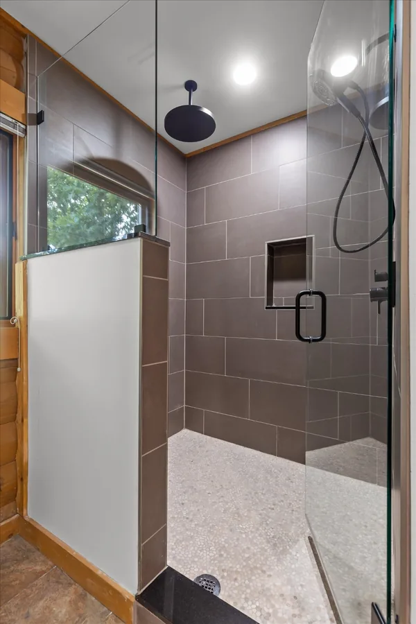 Upstairs bathroom with a new frameless glass shower enclosure and rainfall head