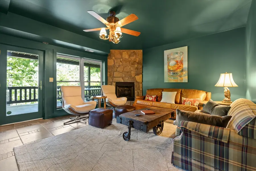 Lower level den with stone fireplace, sofas and armchairs