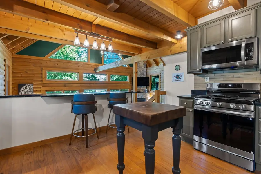 Kitchen island with bar stools beneath pendant lights
