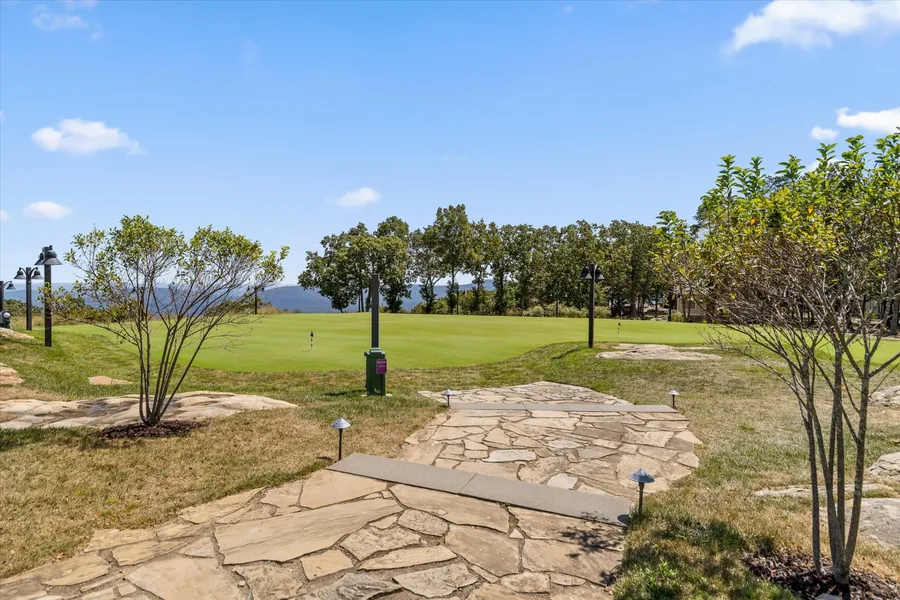 Flagstone path running between young trees toward the open view