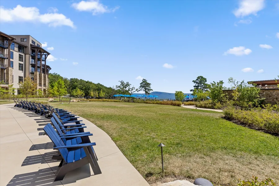 A row of blue Adirondack chairs lined along the edge of the village lawn