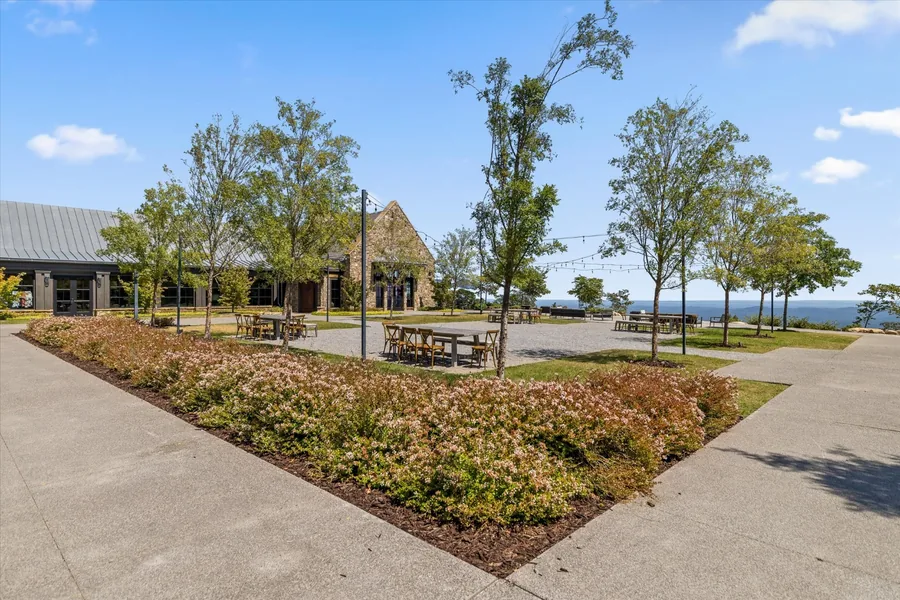 Landscaped courtyard beside The Creag, the putting green and the pro shop with tables under trees