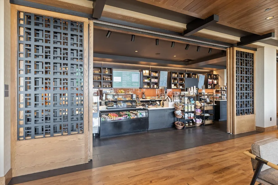 Pocket Cafe counter with pastry cases and a floor-to-ceiling wine rack