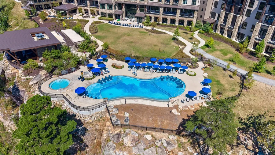 Aerial view of the resort pool with blue umbrellas beside the hotel