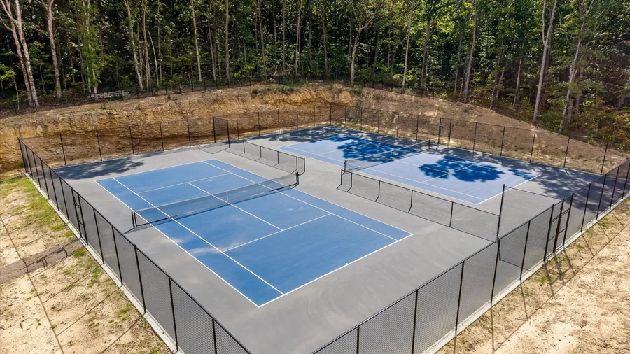 Two fenced tennis courts newly built at West Village
