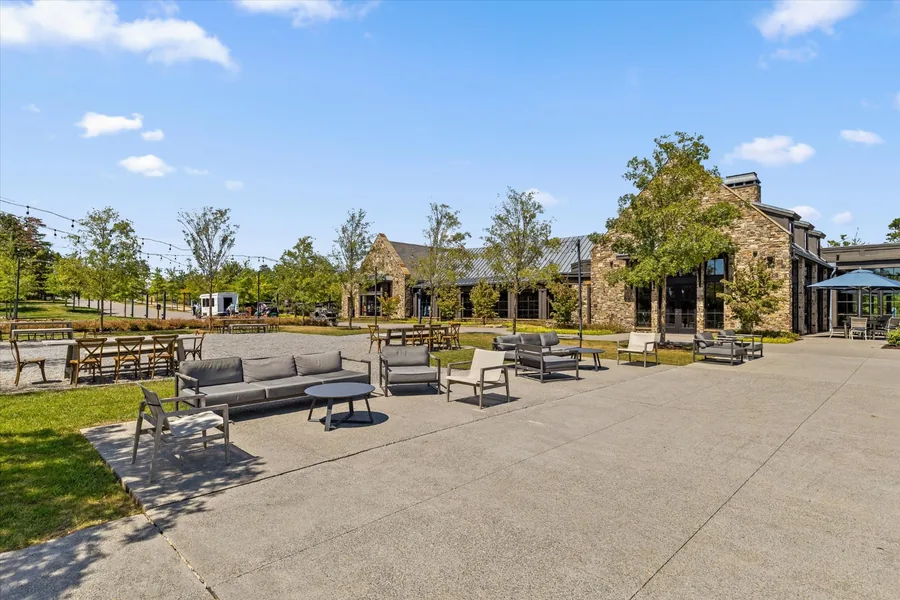 Stone village building with lounge seating and fire pits on the paved lawn