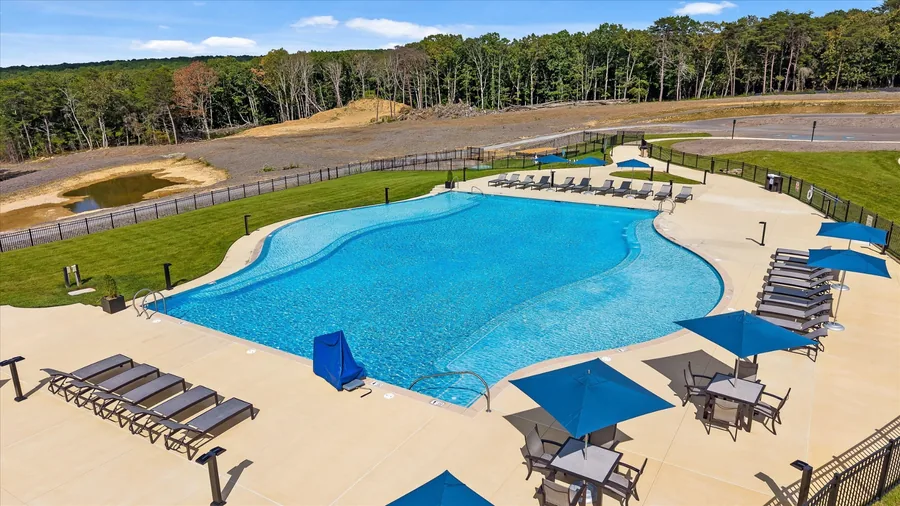 New pool at West Village with loungers and blue umbrellas along the deck