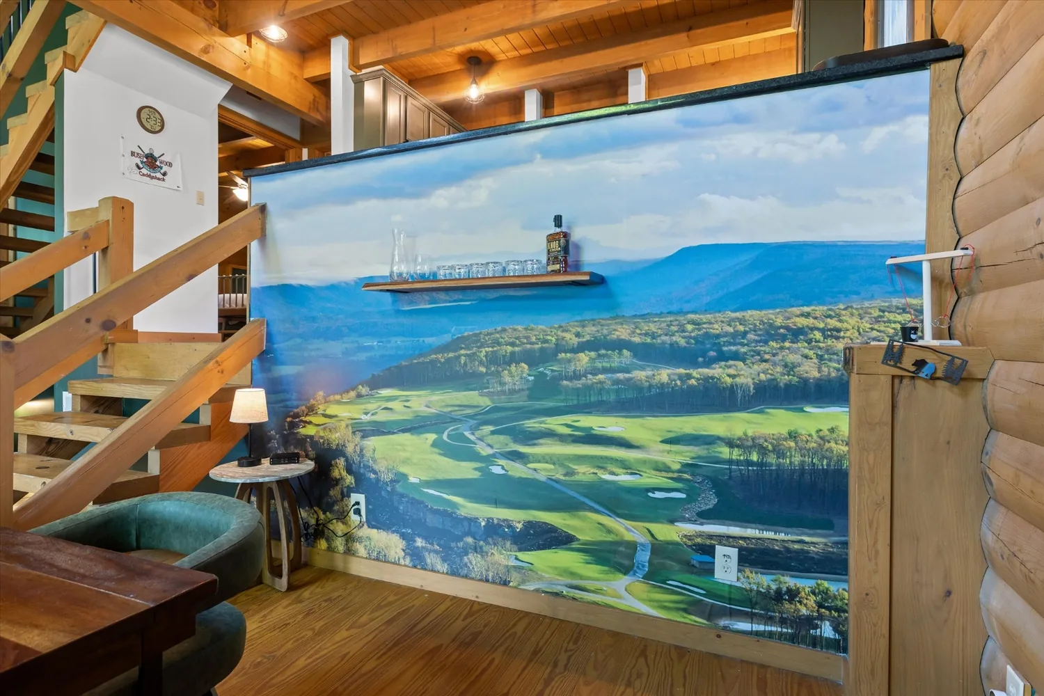 Close view of the Keep mural filling the dining wall beside the log staircase
