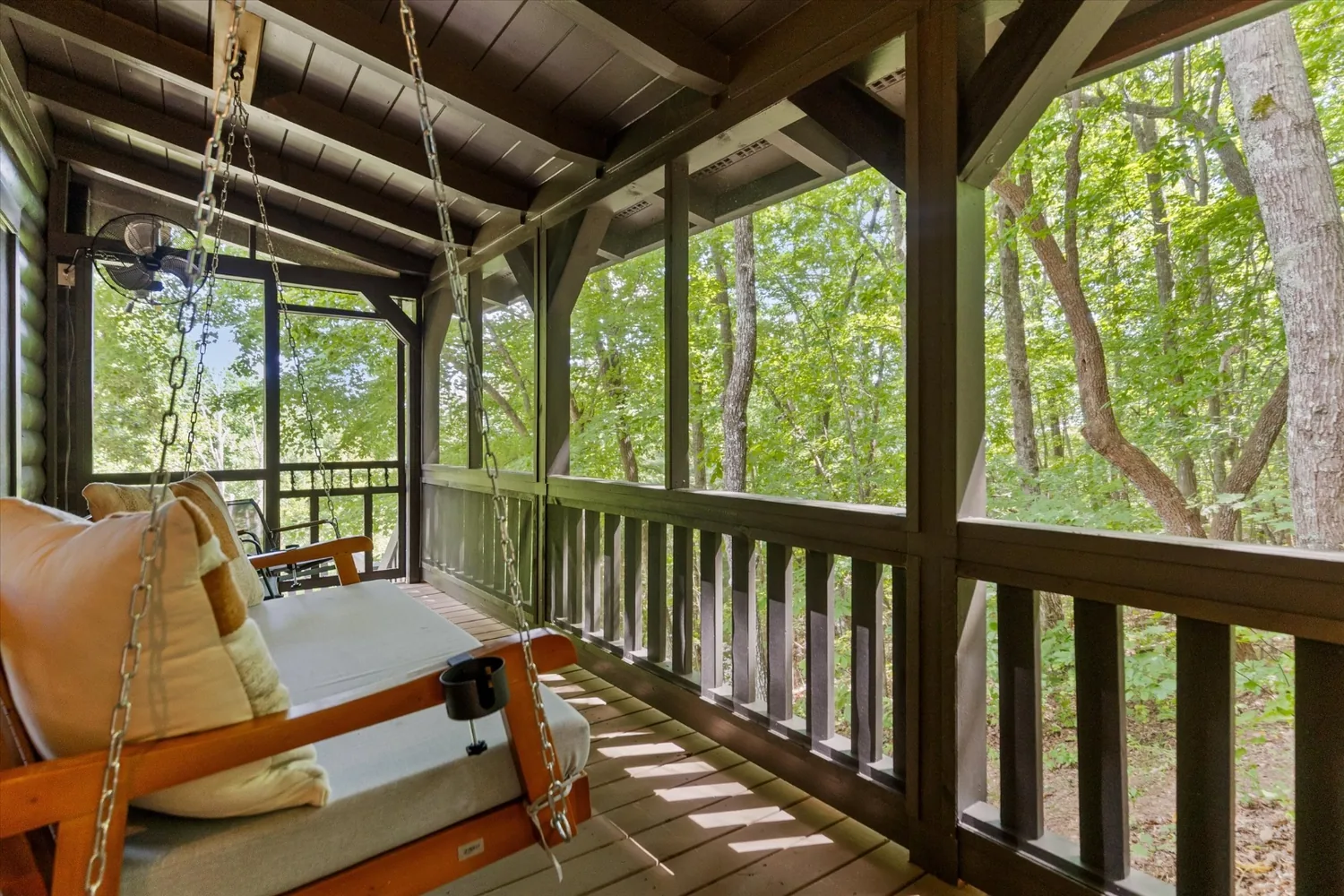 Hanging porch swing on the screened porch looking out into the hardwoods